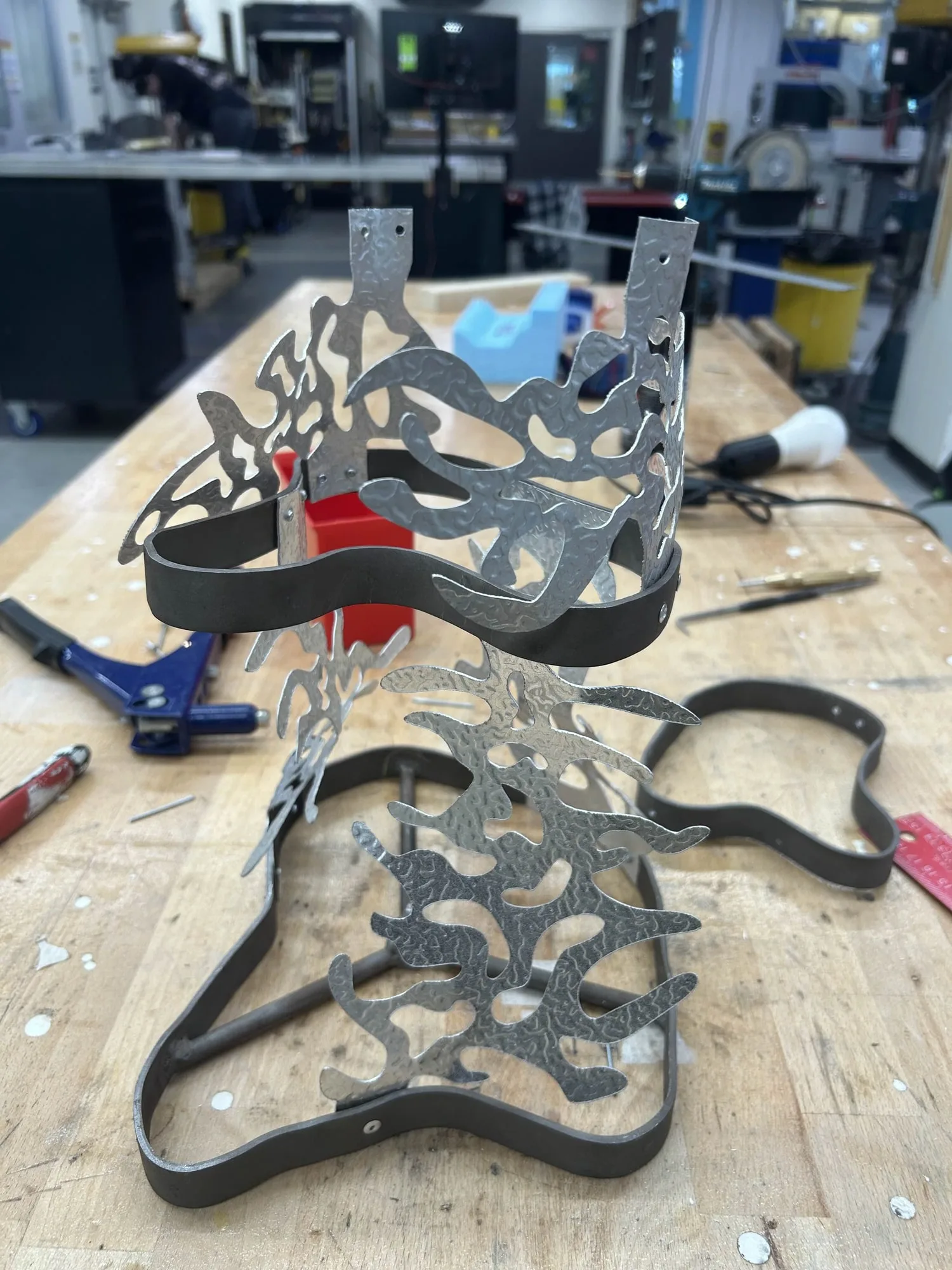 The black layers laid out on the workbench mid-assembly, tools around them.