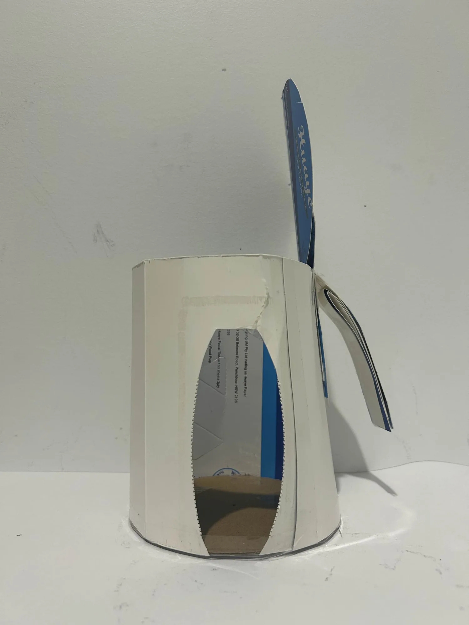 Card and blue foam mock-up standing on a benchtop, used to judge overall proportion and where the lid sits.