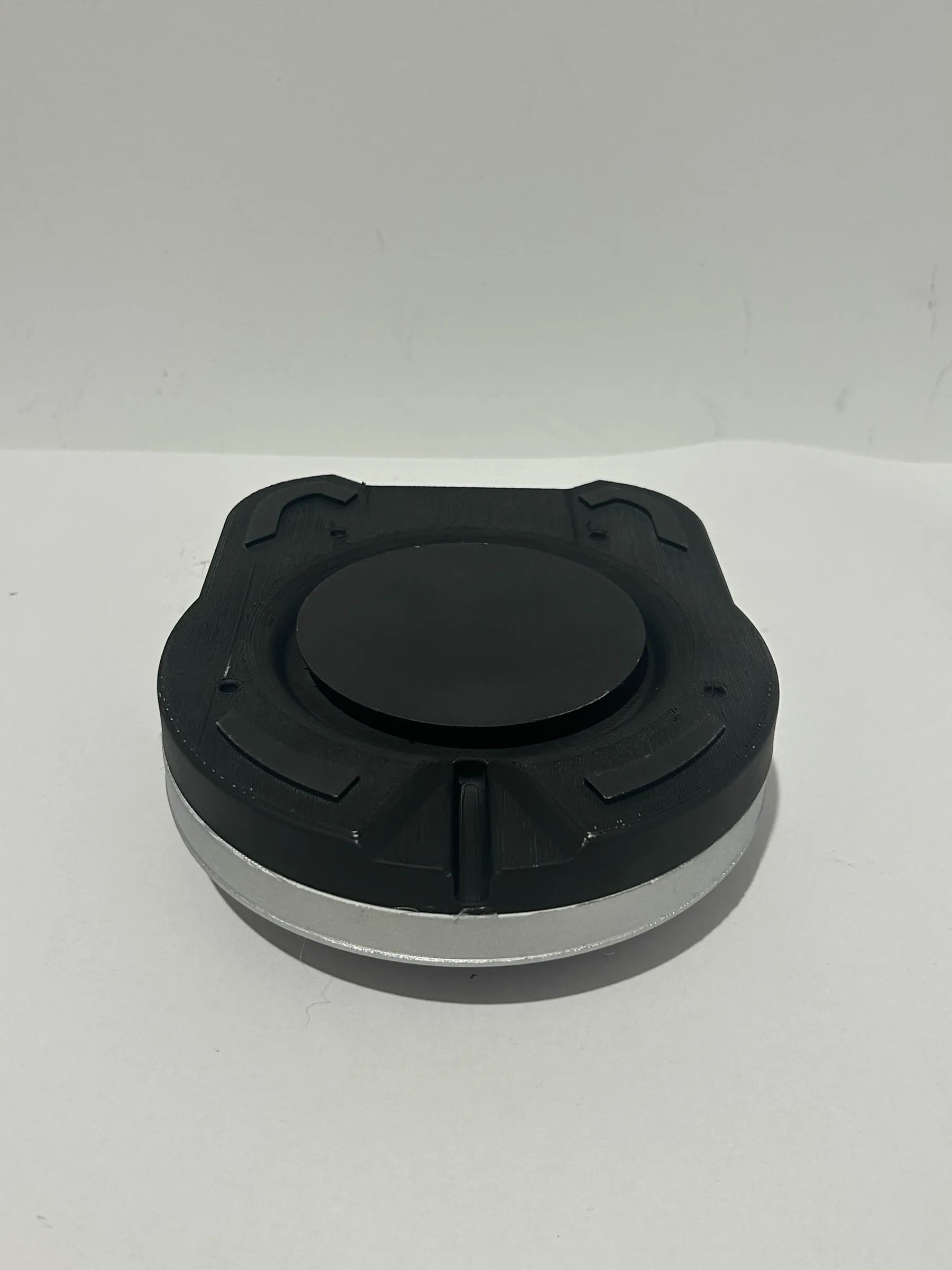 The underside of the base, its black foot plate and central contact set into the brushed silver rim.