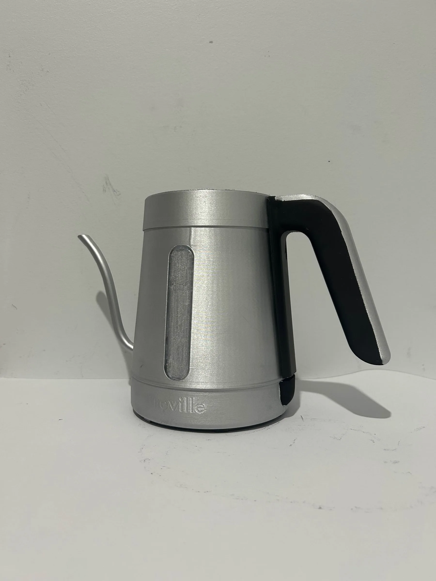The appearance model off its base, side on, with the gooseneck spout and black handle.