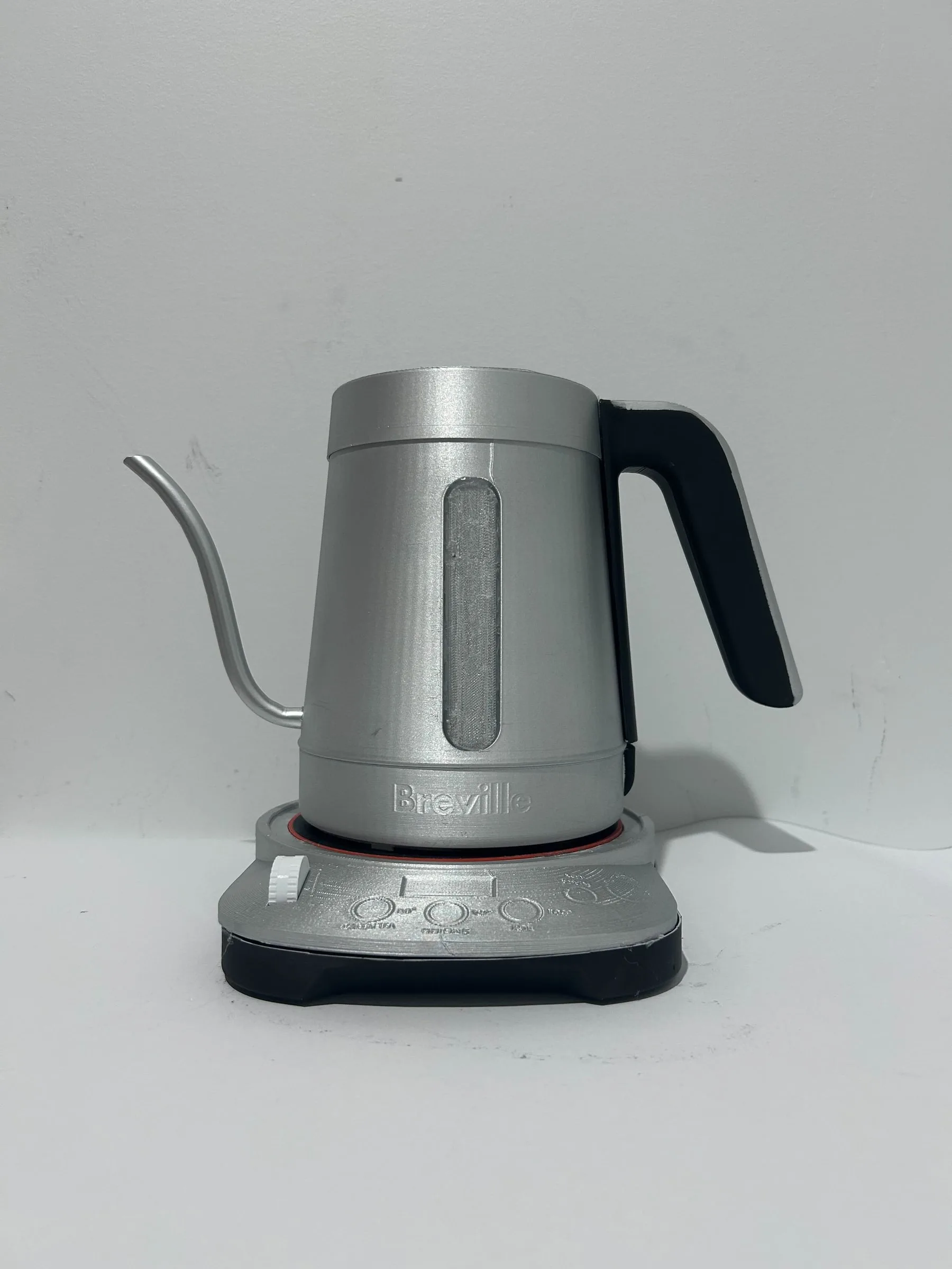 The appearance model seated on its base, spout left and handle right.