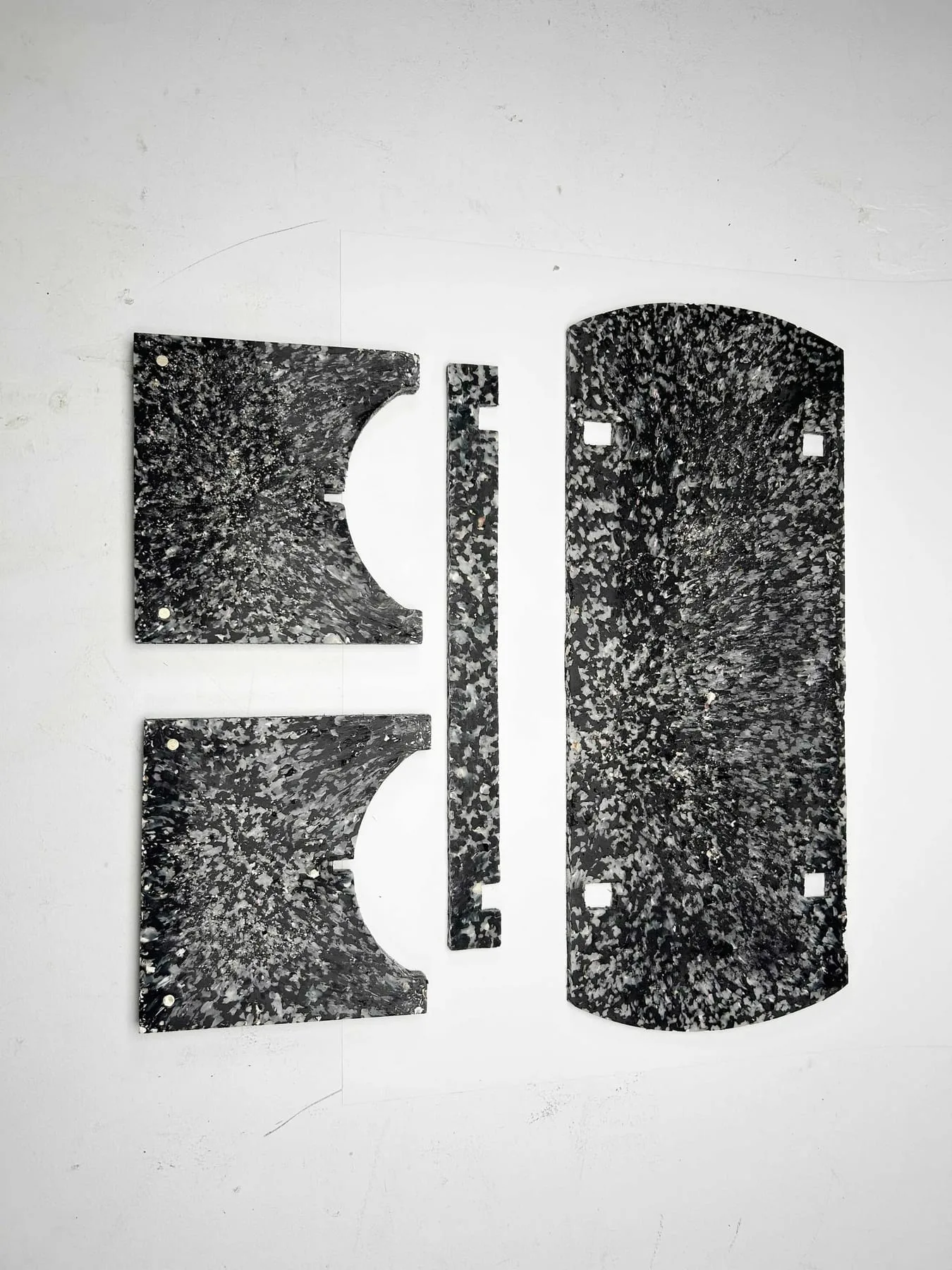 The four flat-pack components of the bench laid out, showing the terrazzo-like shell composite.