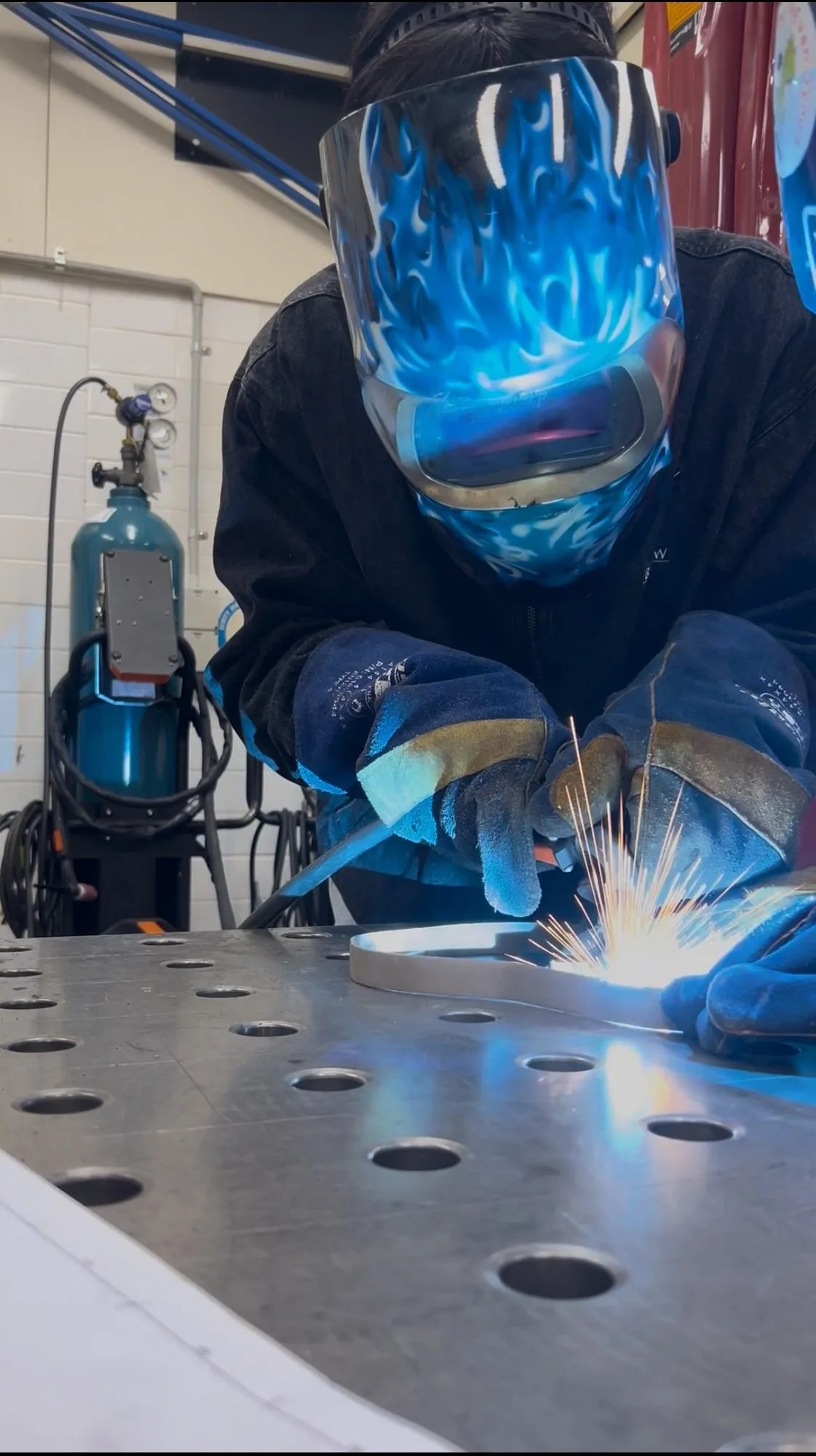 MIG welding the steel bars, arc lit blue.